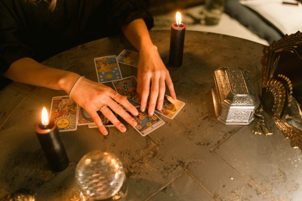 pexels-photo-6014326-6014326 A fortune teller uses tarot cards and candles in a mystical indoor setting.