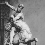 Black and white photo of a detailed marble sculpture of Hercules fighting a centaur in Tuscany, Italy.